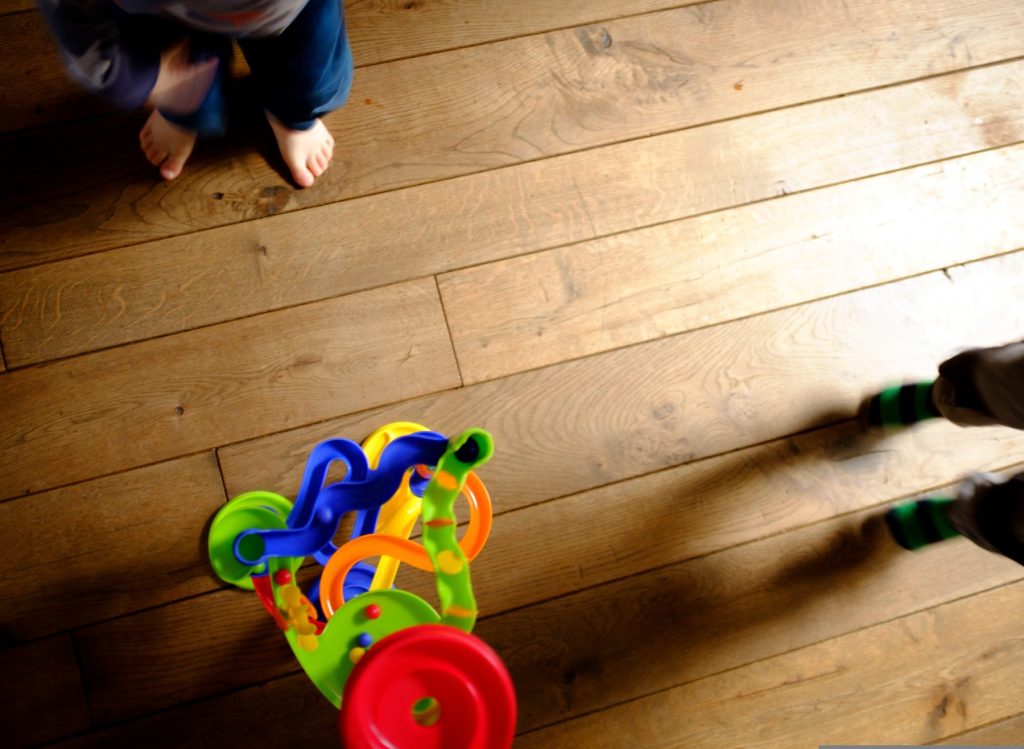 Enfant qui joue sur un parquet huilé